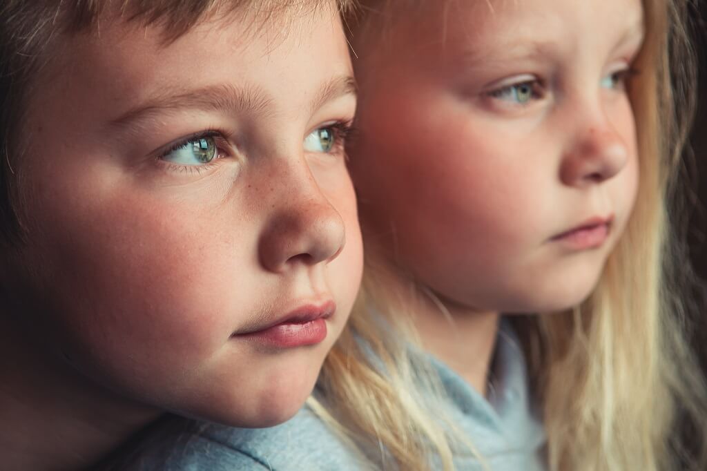 Photo shows the earnest, loving, thoughtful face of a young boy with his sister. We can imagine him taking bold action.